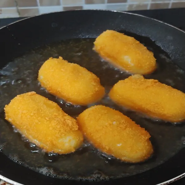 Panaskan minyak goreng, lalu goreng kroket kentang sampai berubah warna kecoklatan.