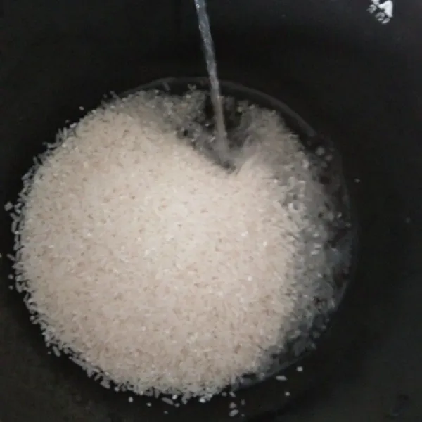 Dalam panci magicom cuci beras hingga bersih.