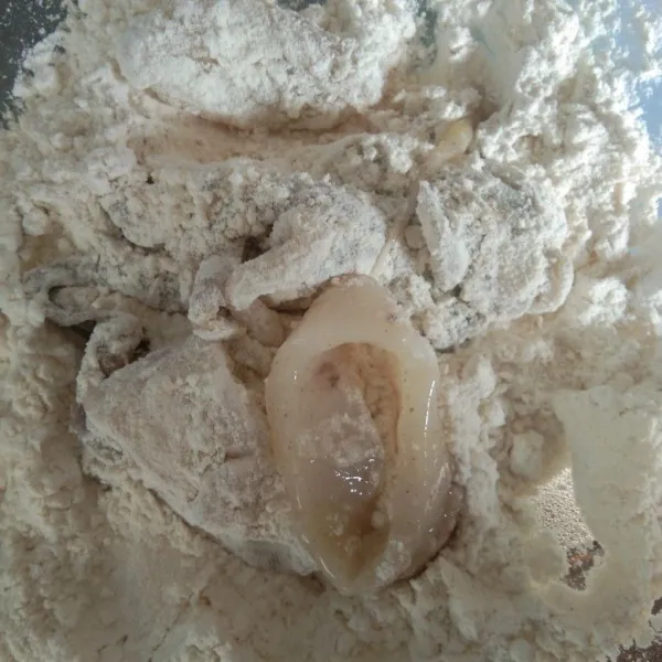 Gulingkan potongan cumi ke dalam adonan tepung, remas-remas agar tepung menempel.