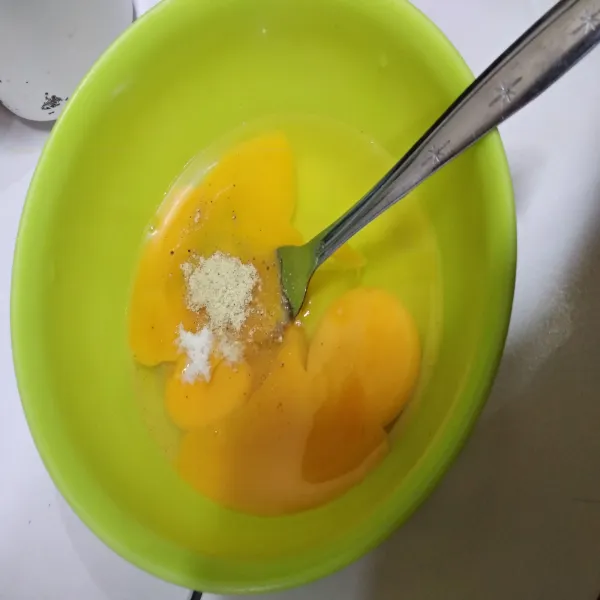 Siapkan wadah, masukkan telur, beri garam dan kaldu bubuk secukupnya. Kocok lepas.