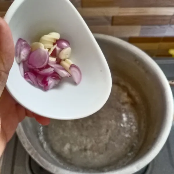 Didihkan air di panci kemudian masukan irisan bawang merah dan bawang putih. Masak sampai mendidih kembali.