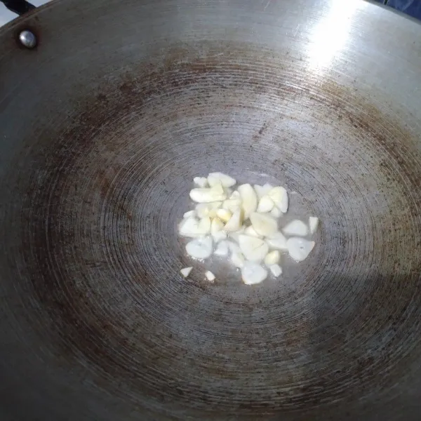 Tumis bawang putih hingga layu dan harum.