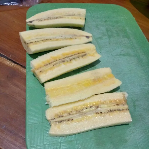 Kupas pisang belah dan potong jadi lima bagian.