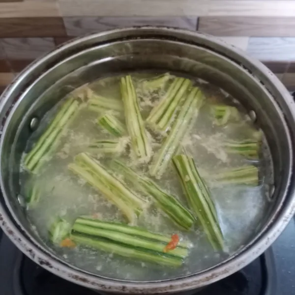 Masukan buah kelor, masak sampai setengah matang .