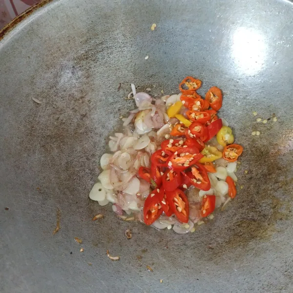 Tumis bawang putih, bawang merah dan lengkuas sampai harum dan matang kemudian masukkan cabe aduk hingga layu.