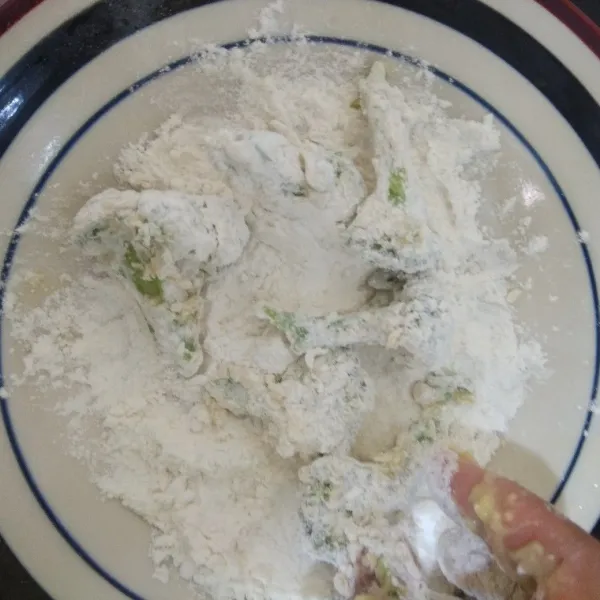 Gulingkan brokoli ke dalam tepung kering hingga rata.