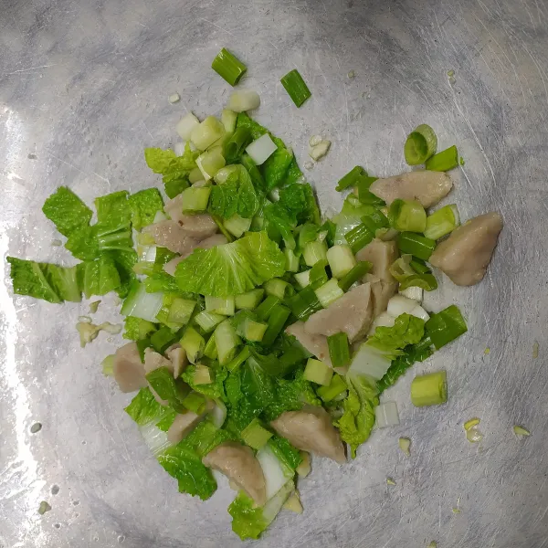Tumis bawang putih cincang sampai harum, masukkan sawi hijau, daun bawang pre dan bakso. Aduk sampai rata.