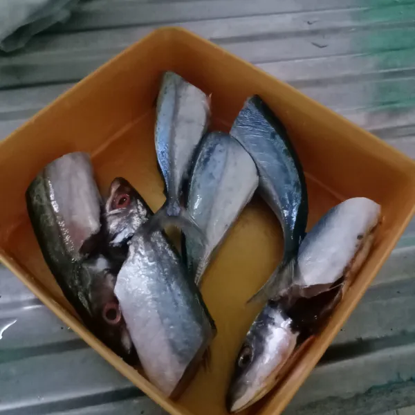 Bersihkan ikan kemudian potong menjadi 2 bagian.
