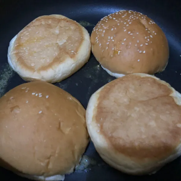 Potong roti burger menjadi dua, siapkan teflon, lelehkan margarin secukupnya, lalu masukkan roti burger (bagian dalam), masak hingga sedikit kecoklatan.