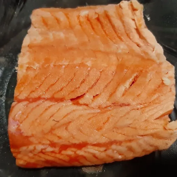 Siapkan daging ikan salmon, periksa durinya lalu buang jika masih menempel.