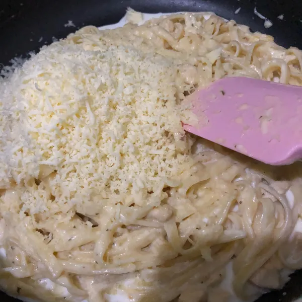 Masukan pasta fettuccine dan mozzarella parut, aduk hingga tercampur rata dan keju mozzarella meleleh.