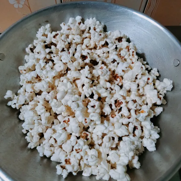 Masukan jagung popcorn, lalu aduk-aduk selama 1-2 menit, kemudian tutup dan biarkan sampai semua popcorn meledak