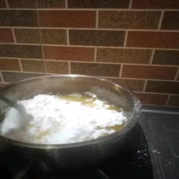 Matikan api, masukan tepung. Aduk rata hingga tidak ada yang bergerindil. Nyalakan kembali, aduk hingga kalis selama ±30 detik.