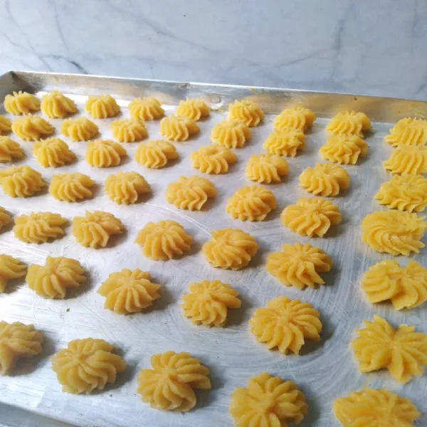 Olesi loyang dengan margarin, semprotkan adonan sesuai selera. Oven hingga matang.