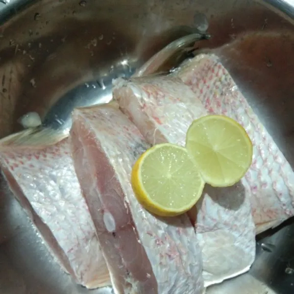 Cuci bersih ikan kakap, lumuri dengan perasan jeruk lemon, aduk rata kemudian bilas keringkan, lalu lumuri dengan garam dan bawang putih bubuk, diamkan minimal 30 menit supaya meresap, goreng ikan kakap hingga matang, tiriskan