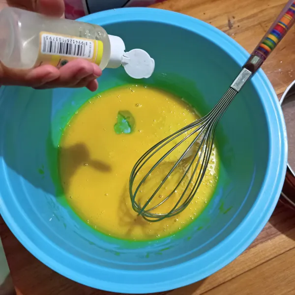 Campur kuning telur, susu cair dan pasta vanila ke dalam wadah.