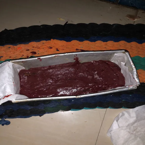 Tuang adonan red velvet cake ke loyang sudah dialasi baking paper dan sisakan sedikit adonan red velvet sebagai hiasan di atas