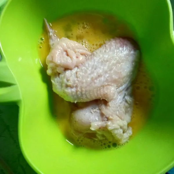 Kocok lepas telur, celupkan ayam dalam telur kocok.