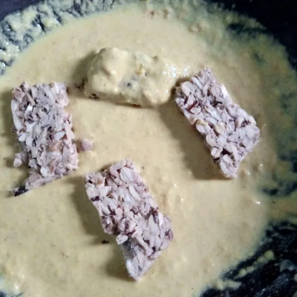 Celupkan tempe dalam tepung bumbu.
