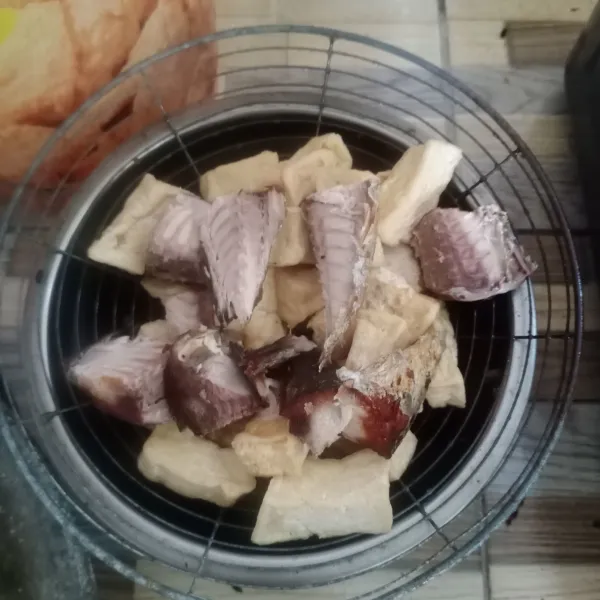 Goreng tahu setengah matang. Kemudian belah ikan tongkol yang sudah digoreng.