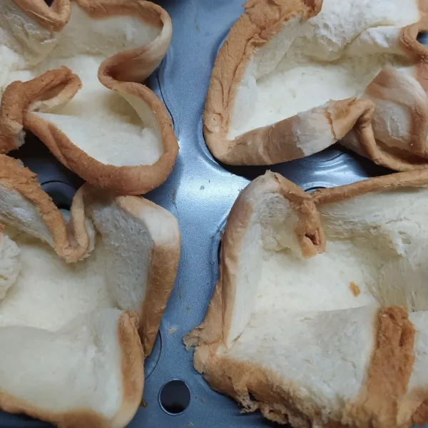 Gilas roti tawar dengan rolling pin, masukan dalam cetakan muffin.