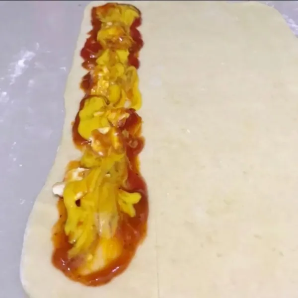 Gilas puff pastry bentuk persegi panjang, beri saus spagety dan mustard di sepertiga sisi ujungnya