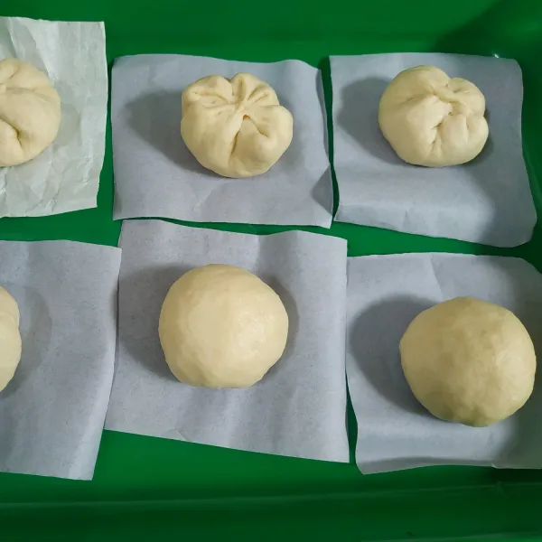 Ambil 1 buah adonan pipihkan dan tambahkan selai secukupnya kemudian bulatkan kembali, alasi adonan yang sudah diberi isian dengan kertas roti. Lakukan hingga semua adonan habis, dan istirahatkan selama 10 menit.