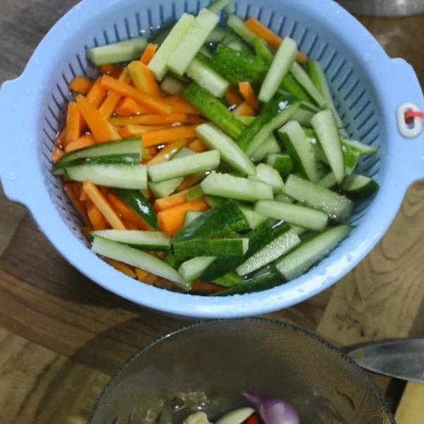 Potong timun dan wortel korek api, untuk timun buang isinya. Cuci dengan air garam bersama dengan cabe rawit hijau.