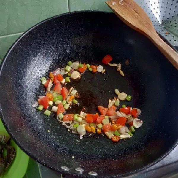 Tumis bawang merah, bawang putih, cabai, tomat dan daun prei sampai harum.