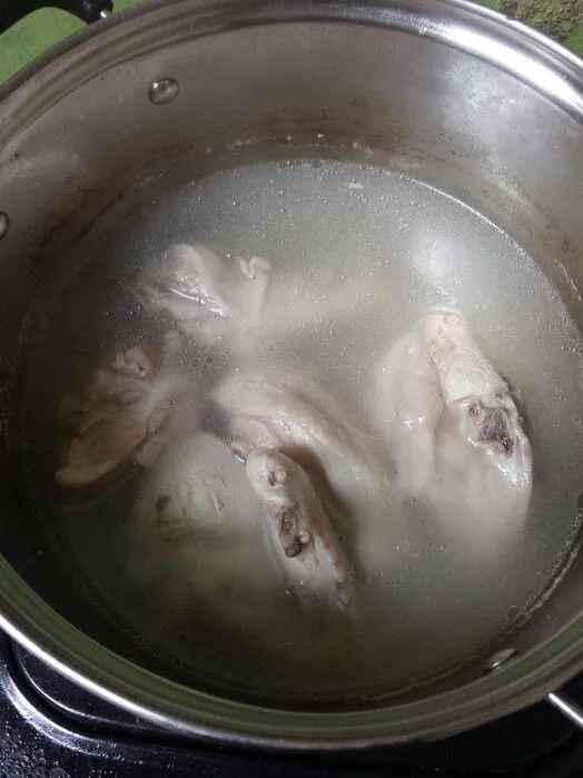 Rebus ayam yang telah dibersihkan hingga setengah matang, angkat dan sisihkan lalu beri garam.