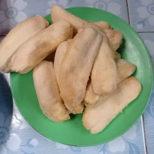 Kupas pisang, lalu belah menjadi 2 bagian.