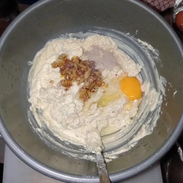 Pindahkan tahu yang sudah halus ke dalam wadah, masukkan lagi 1 butir telur, dan bumbu yang sudah ditumis.