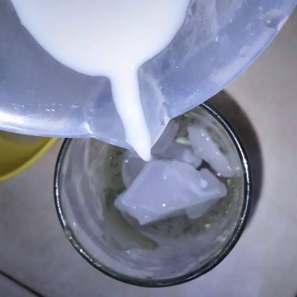 Masukkan es batu ke gelas greentea tadi lalu masukkan campuran susu cair.