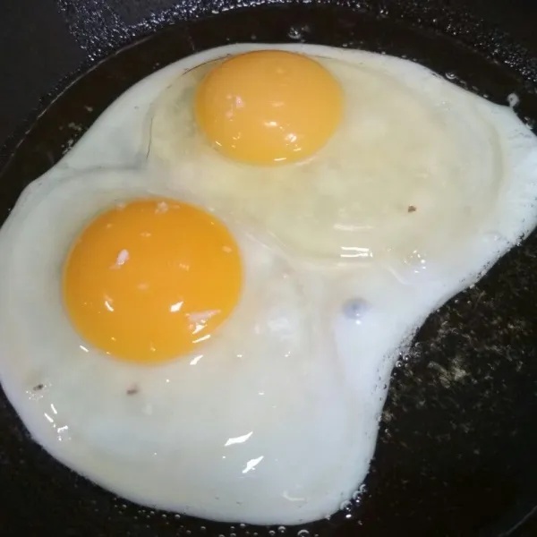 Panaskan 5 sdm minyak sayur pecahkan telur sambil disiram - siram dengan minyak panas