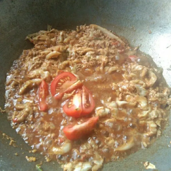 Tambahkan irisan tomat, masak hingga tomat layu