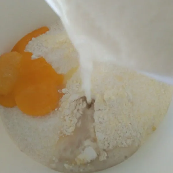 Dalam wadah campur tepung terigu, susu bubuk, gula pasir, dan kuning telur. Masukkan juga larutan ragi, uleni hingga rata