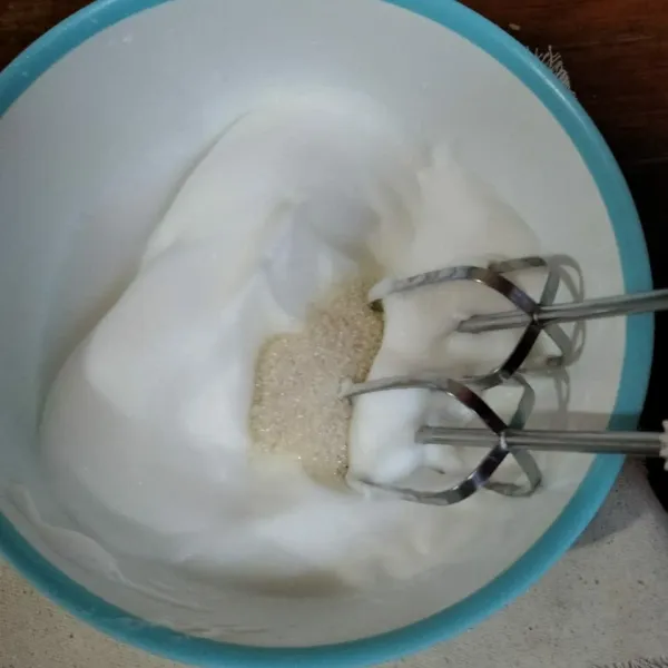 Mixer putih telur hingga berbusa, masukkan gula pasir secara bertahap (3 tahap) sambil terus dimixer hingga soft peak (jika mixer diangkat akan membentuk jambul yang melengkung).