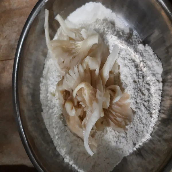 Masukan jamur ke dalam tepung lalu aduk hingga rata
