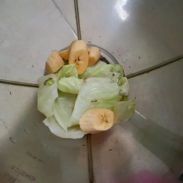 Blender kubis dan setengah buah pisang, tambahkan sedikit air. Tuang di gelas