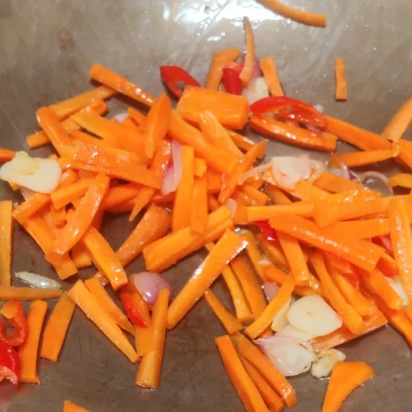 Lalu masukan wortel yang sudah dipotong memanjang, aduk rata bersama bumbu tambahkan sedikit air supaya wortel cepat empuk.