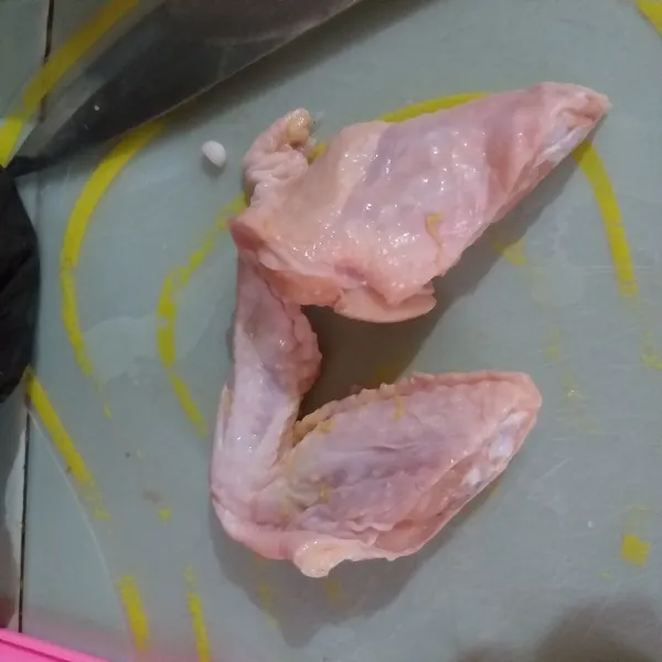 Potong sayap ayam menjadi dua bagian.
