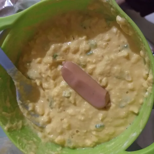 Masukan sosis, ke dalam adonan kemudian balur rata.