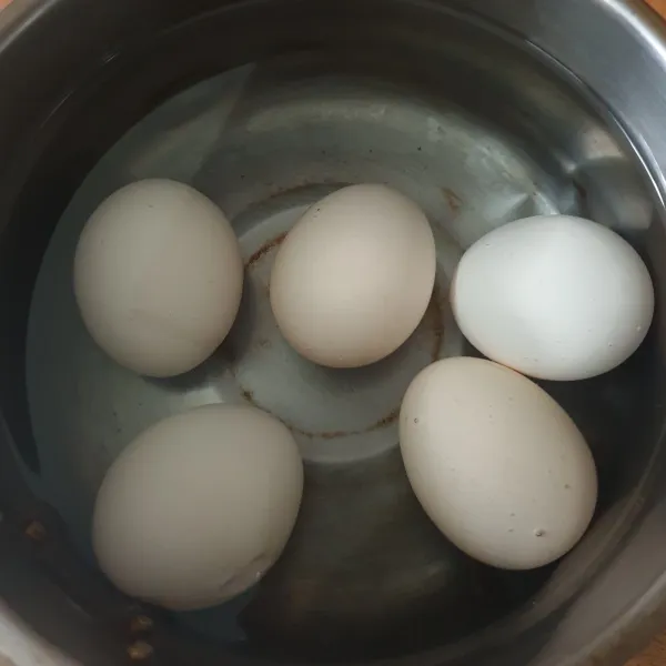 Rebus telur sampai matang. Rendam air dingin