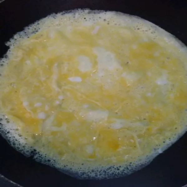 Panaskan teflon, lalu tuangkan telur.
