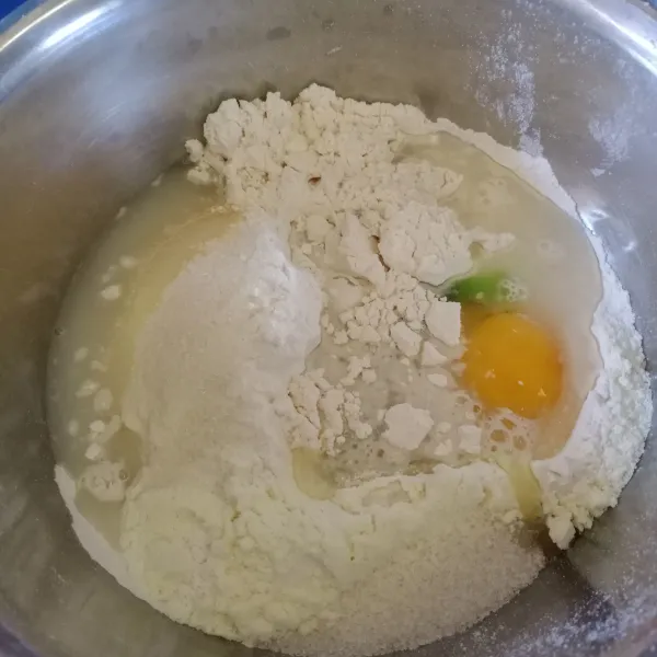 Masukan kedalam wadah tepung terigu, ragi instan, susu bubuk, gula pasir, kuning telur, pasta pandan dan air. Uleni sampai tercampur rata.