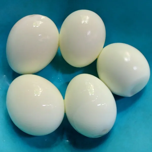 Rebus telur hingga matang, lalu kupas kulitnya.