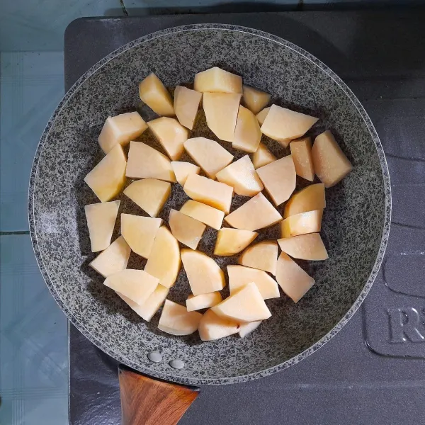 Tumis kentang sampai terlihat warna menjadi transparan, kemudian masukkan wortel. Tambahkan air, kalau bisa tutup wajan agar kentang dan wortel cepat empuk.