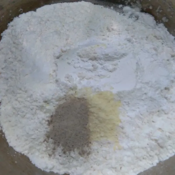 Dalam wadah campur tepung terigu dan tepung beras. Masukkan baking powder, garam, lada bubuk, dan kaldu bubuk lalu campur rata.