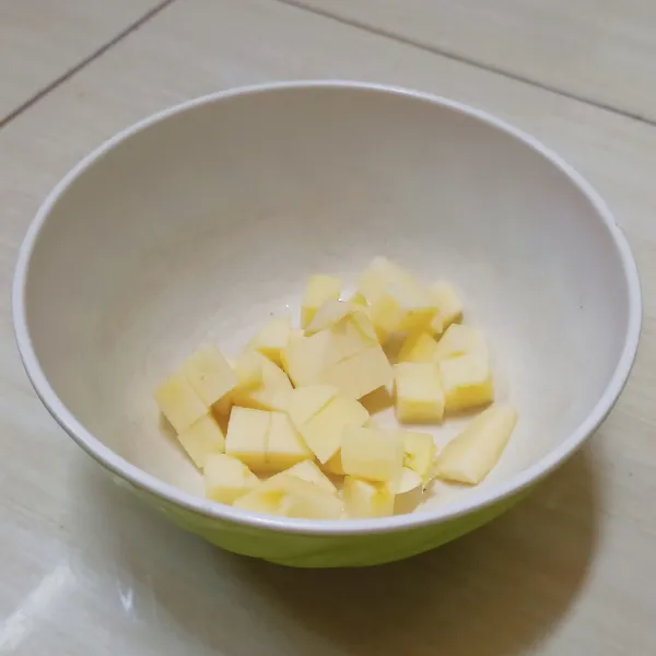 Potong dadu buah apel kemudian masukan ke mangkuk yang agak besar