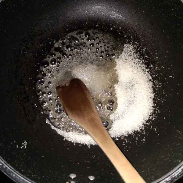 Panaskan gula dan air sampai menjadi karamel. masak dengan api kecil supaya tidak gosong.